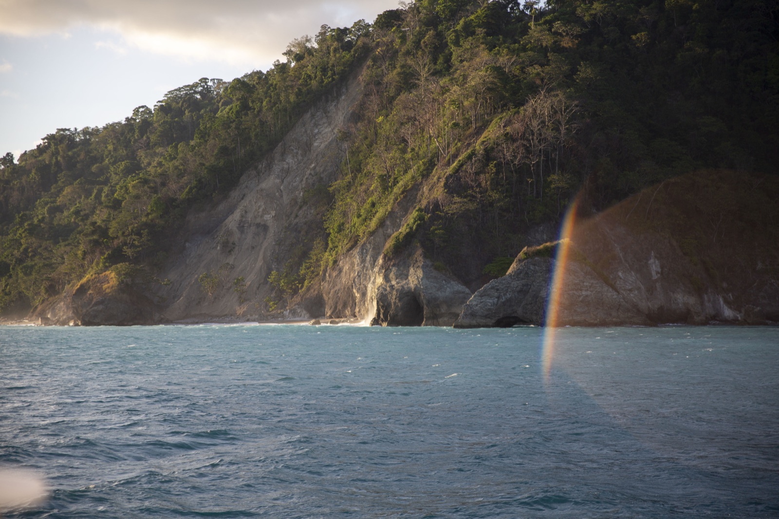 Late sunlight on the coastal cliffs and turquoise water.