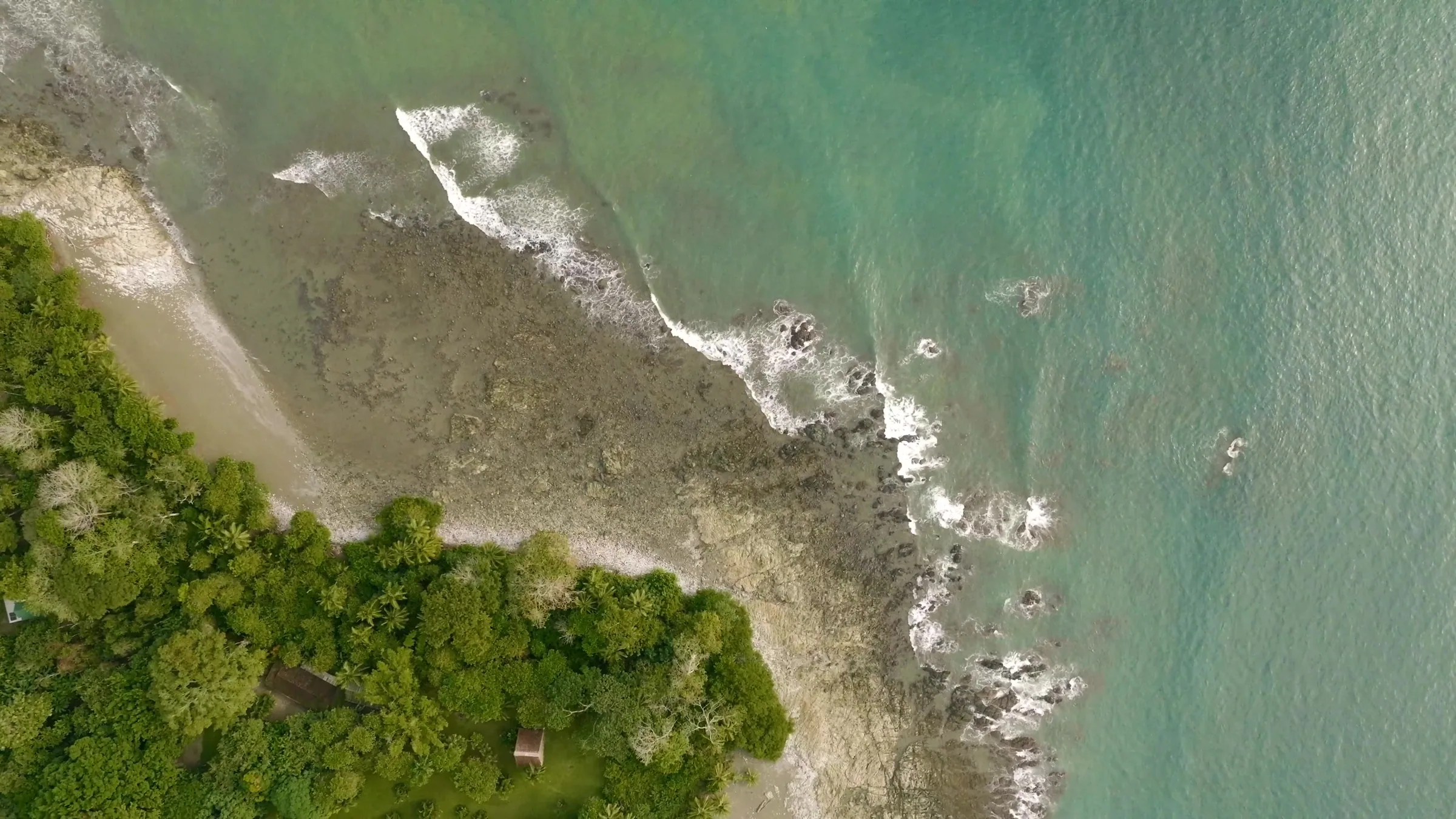 The shoreline at Cabo Matapalo from above, forest meeting surf.