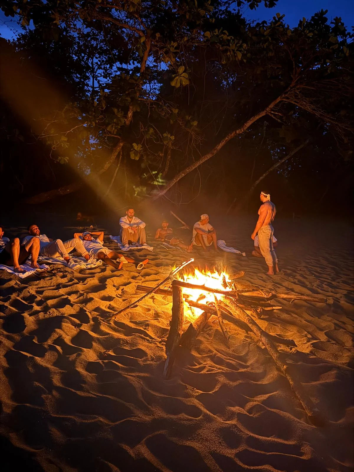The fire on the sand, the circle drawn in around it.